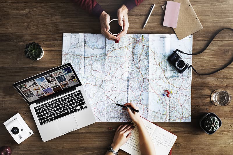 map, computer, camera, people's hands, planning a trip